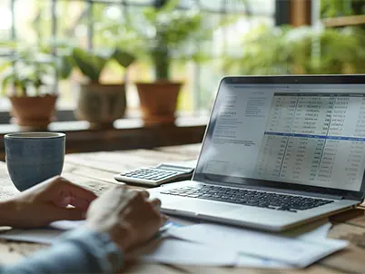 Laptop and calculator setup for outsourced catch-up bookkeeping solutions