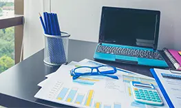 Organized workspace with laptop, calculator, and financial documents for the best outsourced accounting services in North Carolina.