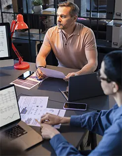 A business consultant and startup founder discussing financial reports and metrics to optimize accounts receivable services for startups.