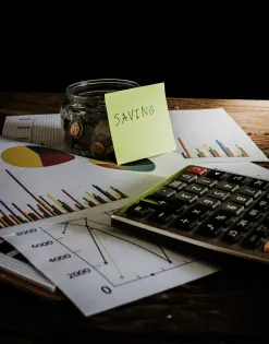 Desk with coffee cup, calculator, and business charts reflecting outsourced tax services for startups to manage financial tasks.