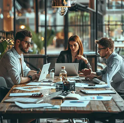 Startup team meeting with laptops and financial reports, supported by online CPA services for startups and financial strategy.