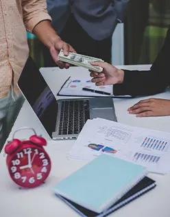 Accountant processing employee salary payments using startup payroll services.