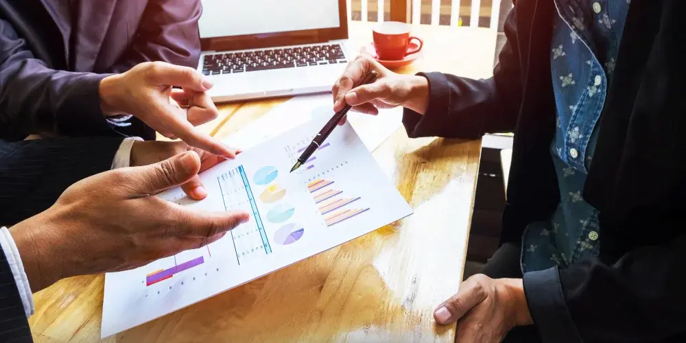 Business professionals reviewing financial reports, charts, and performance analytics during a strategic planning meeting.