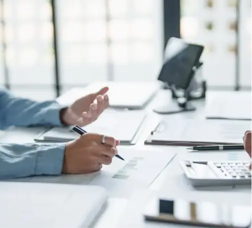 Accountant discussing financial reports with a client during an outsourced accounting consultation.